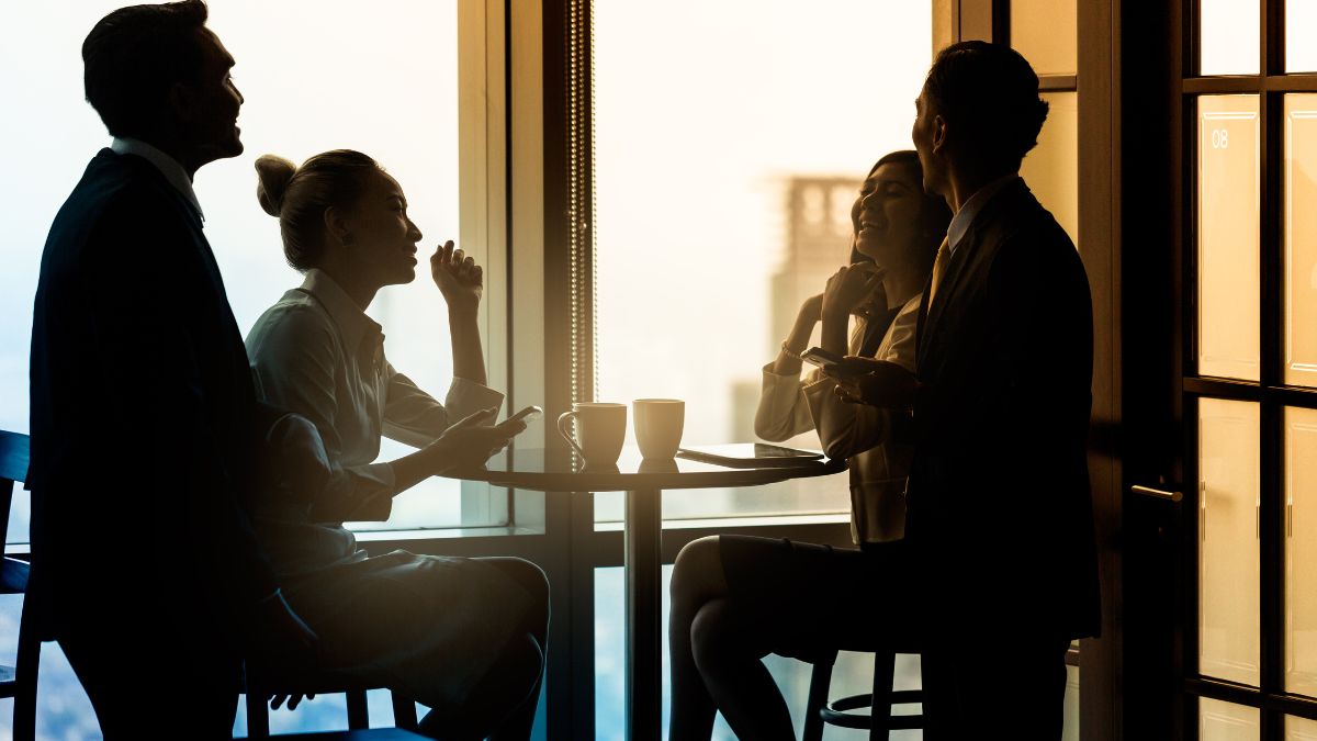 A photo of a group of employees chatting over coffee