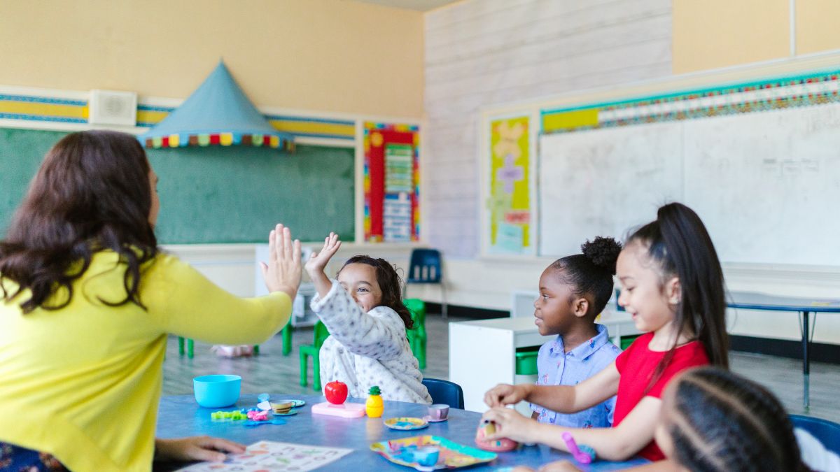 A teacher giving a high-five to one of her students inside the classroom